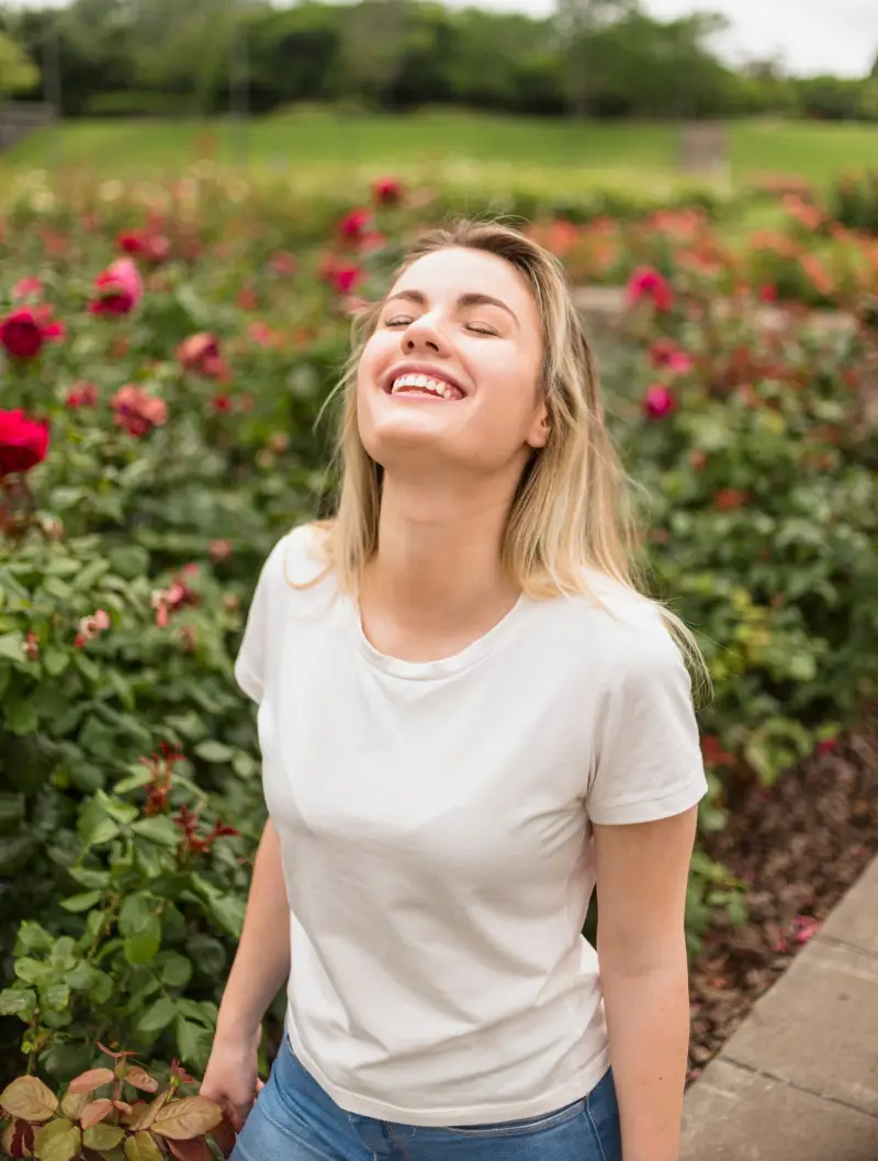 Happy woman standing in flower garden